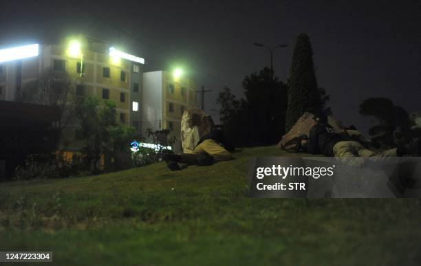 Policemen take position near the site of an attack to a police compound in Karachi on February 17, 2023. - A gunbattle was raging inside a Pakistan...