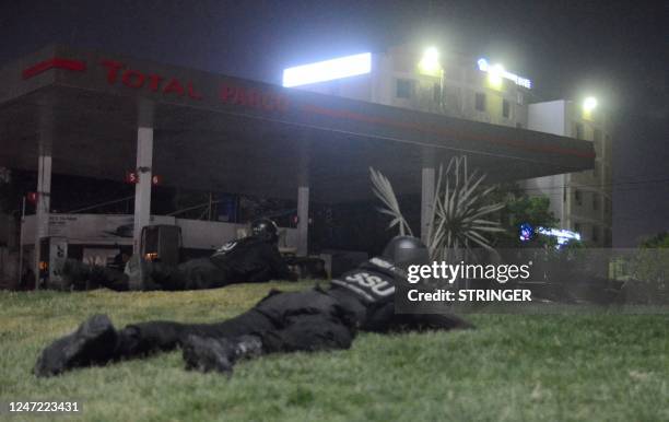 Policemen take position near the site of an attack to a police compound in Karachi on February 17, 2023. - A gunbattle was raging inside a Pakistan...