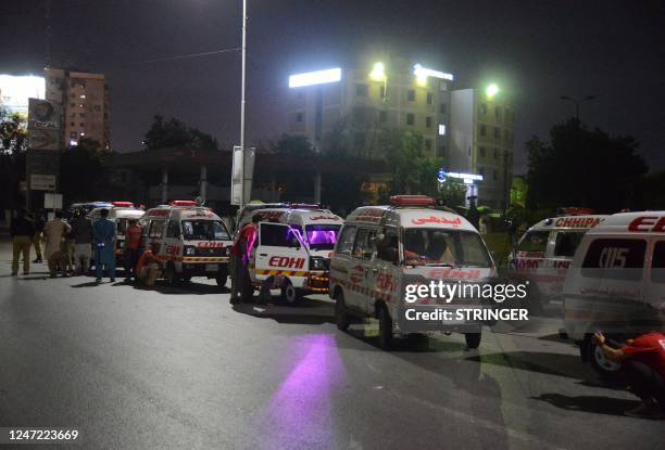 Ambulances are seen near the site of an attack to a police compound in Karachi on February 17, 2023. - A gunbattle was raging inside a Pakistan...