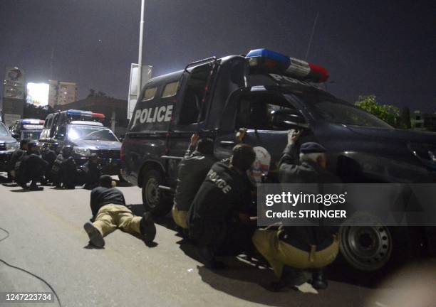 Policemen take position near the site of an attack to a police compound in Karachi on February 17, 2023. - A gunbattle was raging inside a Pakistan...