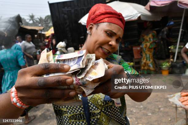 Vendor holds outlawed banknotes rejected by traders at Awgbu market in Anambra State, southeast Nigeria, on February 17, 2023. - Nigeria has been...