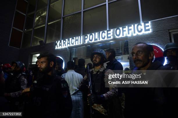 Security personnel stand guard outside a police compound after it was attacked by Pakistani Taliban in Karachi on February 17, 2023. - At least seven...