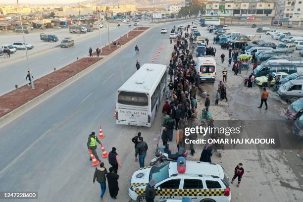 An aerial picture shows Syrian refugees living in Turkey waiting to take a bus through the northern Bab al-Hawa border crossing, on February 17 as...