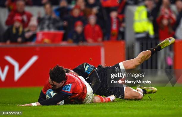 Limerick , Ireland - 17 February 2023; Joey Carbery of Munster scores his side's fourth try despite the tackle of Luke Morgan of Ospreys during the...