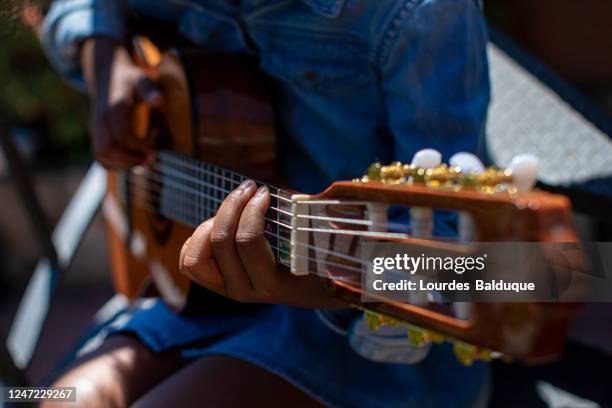 small girl learning to play the guitar - online concert stock pictures, royalty-free photos & images