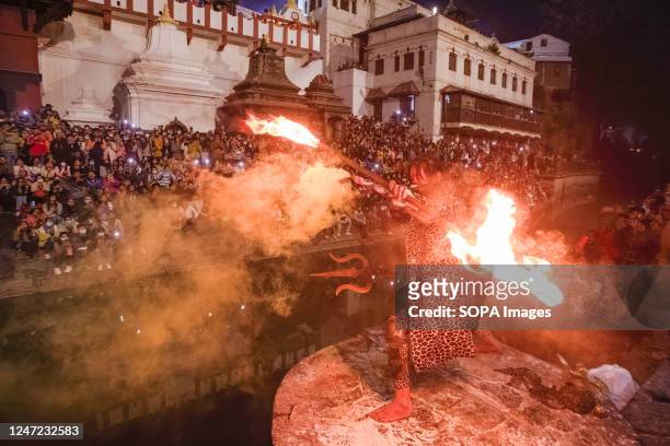 Hindu holy man, or Sadhu, the follower of Lord Shiva, throws ashes as he performs Tandava, a divine dance performed by Deity Shiva, a source of...