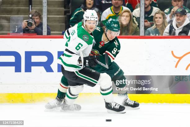 Colin Miller of the Dallas Stars and Kirill Kaprizov of the Minnesota Wild compete for the puck in the first period of the game at Xcel Energy Center...