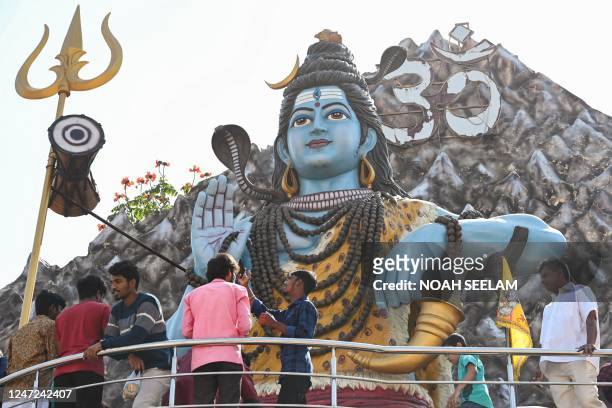 Hindu devotees offer prayers to a statue of Hindu deity Lord Shiva on the occasion of Maha Shivaratri festival, at a Shiva Temple in Hyderabad on...