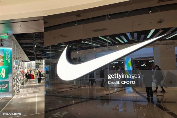 Customers walk past a Nike store in Shanghai, China, February 17, 2023.