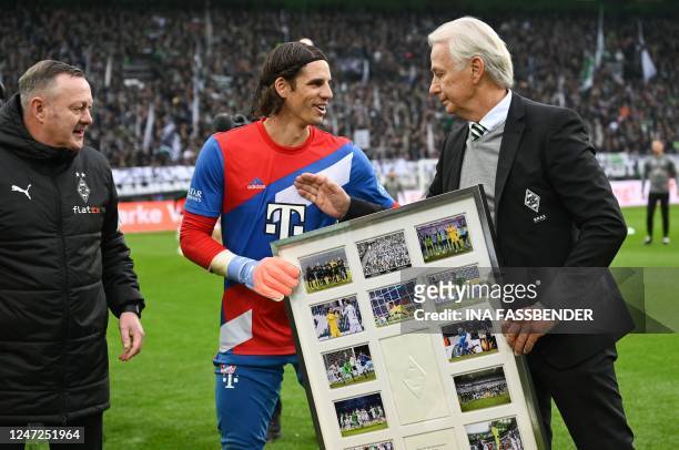 Former Moenchengladbach's Swiss goalkeeper Yann Sommer is handed a farewell gift by Vice President of Borussia-Moenchengladbach Rainer Bonhof the...