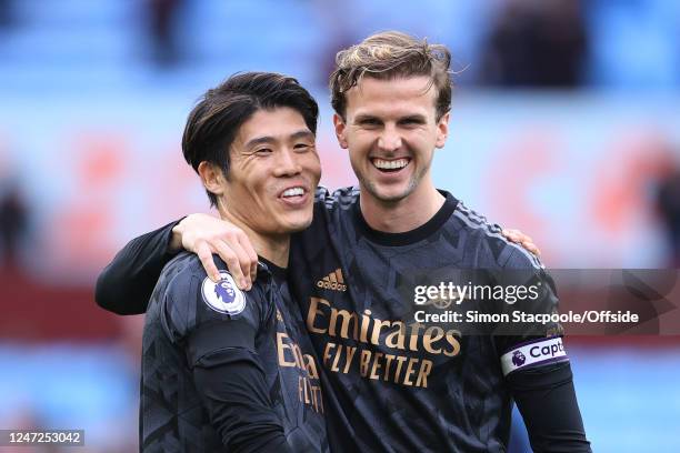 Takehiro Tomiyasu of Arsenal and Rob Holding of Arsenal celebrate victory after the Premier League match between Aston Villa and Arsenal FC at Villa...