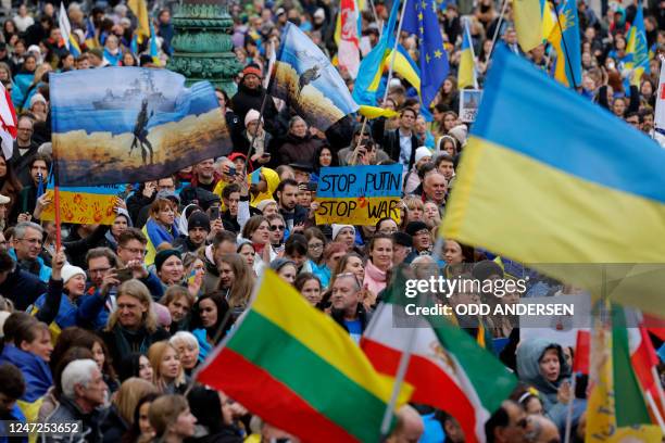 Demonstrators wave flags of Ukraine, Iran, Europe, Lithuania and others as they take part in a pro-Ukrainian rally at Odeonsplatz square on the...