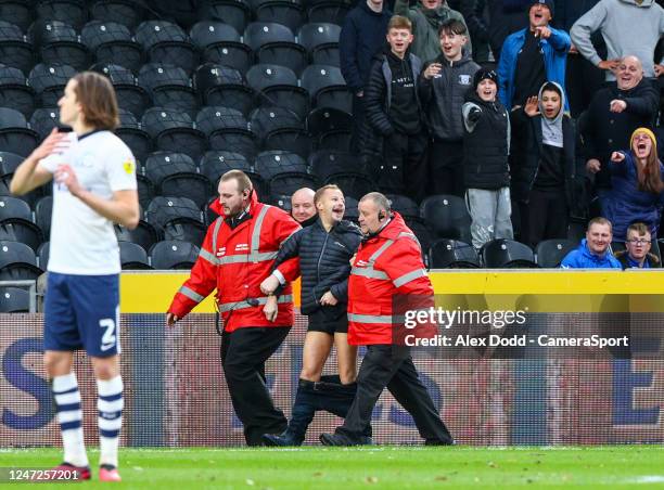 Pitch invaders trousers fall down as he is escorted from the stadium during the Sky Bet Championship between Hull City and Preston North End at MKM...