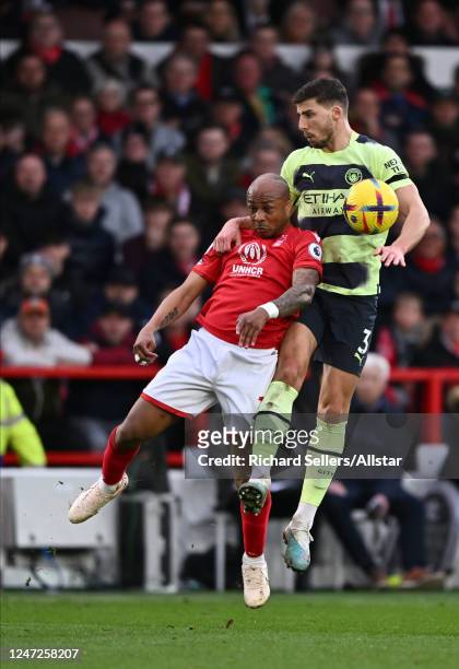 Andre Ayew of Nottingham Forest and Ruben Dias of Manchester City challenge during the Premier League match between Nottingham Forest and Manchester...