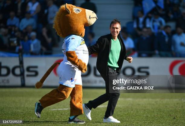 French winner of "La Diagonale des fous" trail race Benat Marmissolle runs with Aviron Bayonnais's mascot Pottoka before the start of the French...