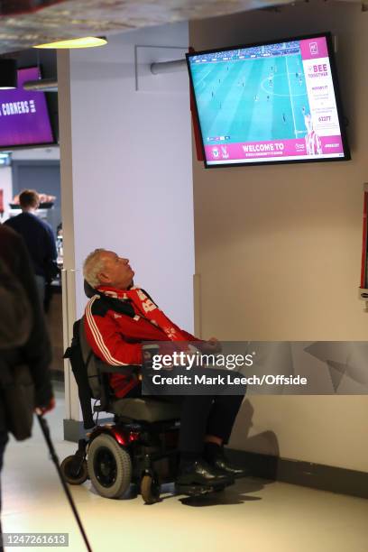 A man in a wheelchair watches the earlier match on a television in the bar area before the Premier League match between Brentford FC and Crystal...