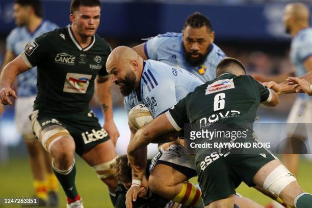 Perpirgan's French hooker Mike Tadjer is tackled by Pau's French flanker Martin Puech during the French Top14 rugby union match between USA Perpignan...