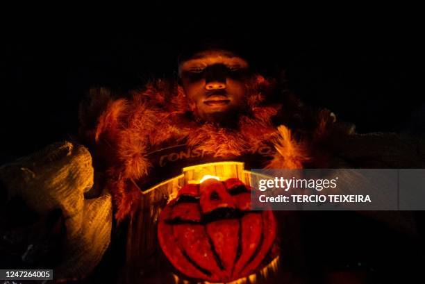 Member of the "Constelação" bate-bola street carnival band prepares to parade in Rio de Janeiro's suburb Vila Aliança, Brazil, on February 18, 2023....