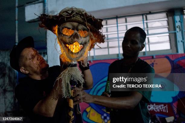 Members of the "Constelação" bate-bola street carnival band prepare to parade in Rio de Janeiro's suburb Vila Aliança, Brazil, on February 18, 2023....