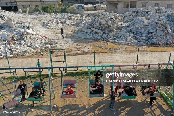 An aerial view shows children playing by the rubble of destroyed buildings in the village of Azmarin in Syria's rebel-held northwestern Idlib...