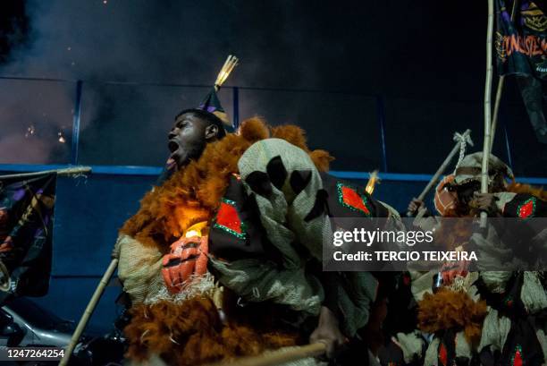 Members of the "Constelação" bate-bola street carnival band parade in Rio de Janeiro's suburb Vila Aliança, Brazil, on February 18, 2023. - The...