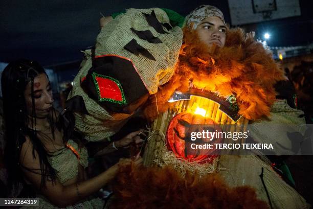 Members of the "Constelação" bate-bola street carnival band prepare to parade in Rio de Janeiro's suburb Vila Aliança, Brazil, on February 18, 2023....