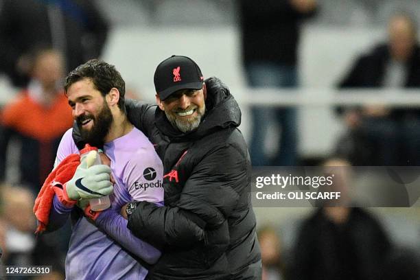 Liverpool's German manager Jurgen Klopp congratulates Liverpool's Brazilian goalkeeper Alisson Becker at the end of the English Premier League...