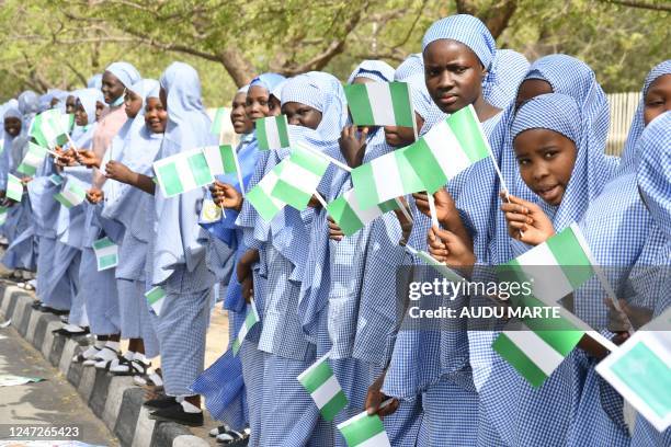 Students of Yerwa Government girls secondary school Maiduguri hold Nigerian national flags during an All progressives Congress rally in Maiduguri on...