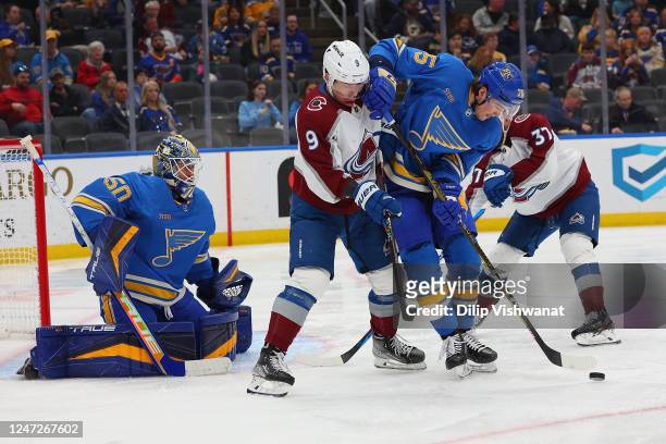 Jordan Binnington and Tyler Tucker of the St. Louis Blues defend the goal against Evan Rodrigues of the Colorado Avalanche in the second period of...