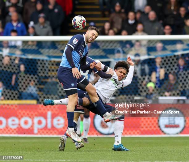 Wycombe Wanderers' Josh Scowen heads the ball under pressure from Bolton Wanderers' Shola Shoretire during the Sky Bet League One between Bristol...