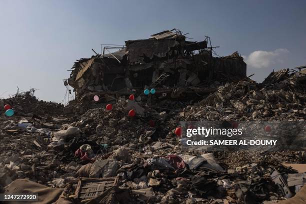 This photograph taken on February 18, 2023 shows ballons on a collapsed buildings in the city of Antakya. 8-magnitude earthquake hit near Gaziantep,...