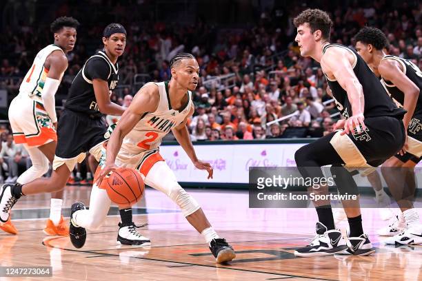 Miami guard Isaiah Wong handles the ball while defended by Wake Forest guard Damari Monsanto and forward/center Matthew Marsh in the first half as...