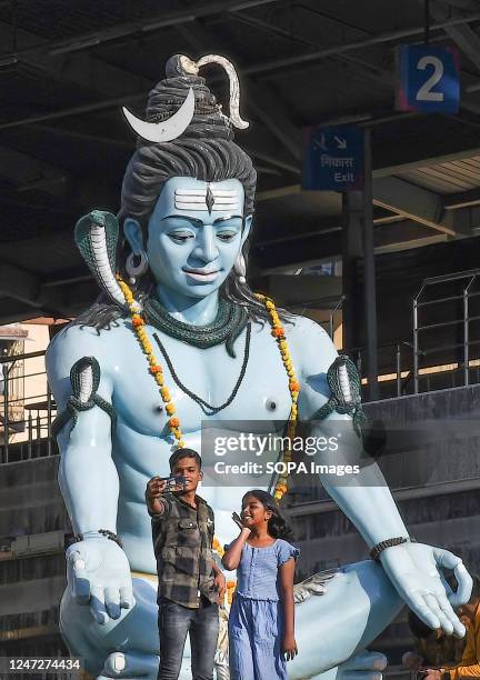 Boy and a girl take a selfie near the statue of Hindu god Shiva on the occasion of Mahashivratri in Mumbai. Mahashivratri is celebrated by Hindus to...