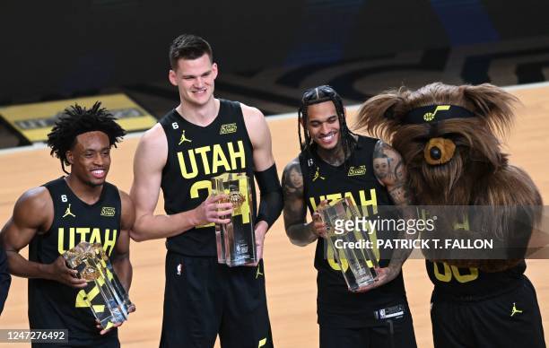Utah Jazz's players Collin Sexton , Walker Kessler , Jordan Clarkson and the team mascot Jazz Bear pose with the winner trophy of the Kia skills...