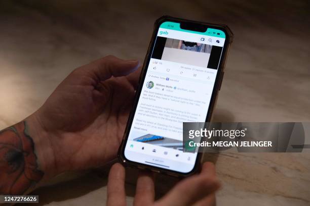 Jessica Watt looks at the app Gab on her phone, where her father, Randy Watt, read misinformed information about the COVID-19 vaccine, at in her home...