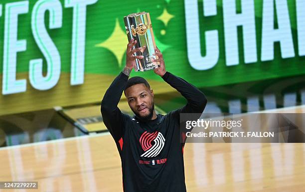 Basketball player Damian Lillard, of the Portland Trailblazers, holds up the trophy after winning the three point contest during NBA All-Star Weekend...