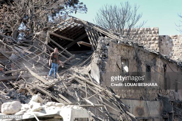 Man inspects damage in the aftermath of an Israeli air strike that hit the medieval Citadel of Damascus on February 19, 2023. - The air strike on...