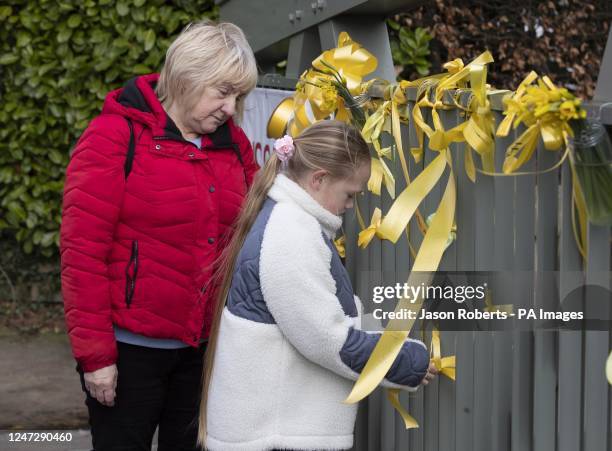 Wendy Adams and Ava Jean tie a yellow ribbon with a message of hope on it to a bridge over the River Wye in St Michael's on Wyre, Lancashire, as...