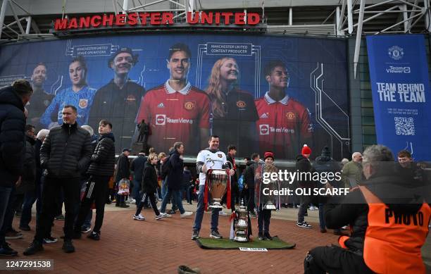 Fans pose for photos outside of Old Trafford stadium in Manchester north west England, ahead of the English Premier League football match between...