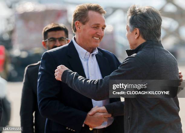 Secretary of State Antony Blinken shakes hands with shakes hands with US Ambassador to Turkey Jeff Flake as he arrives at Incirlik Air Base near...