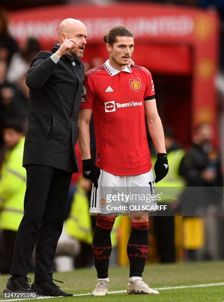 Manchester United's Dutch manager Erik ten Hag gives instructions to Manchester United's Austrian midfielder Marcel Sabitzer during the English...