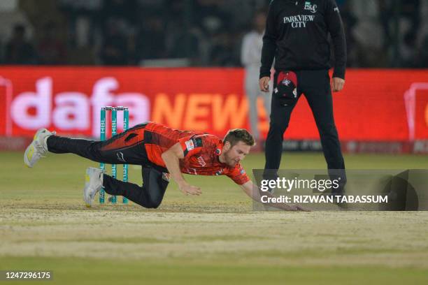 Lahore Qalandars' Liam Dawson dives to catch a ball during the Pakistan Super League T20 cricket match between Karachi Kings and Lahore Qalandars at...