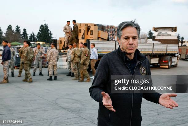Secretary of State Antony Blinken addresses media, as US military personnel load aid onto a vehicle, at Incirlik Air Base near Adana, on February 19...