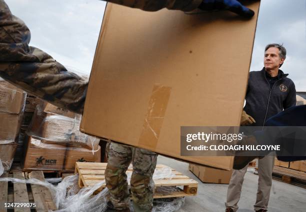 Secretary of State Antony Blinken looks on as US military personnel load aid onto a vehicle, at Incirlik Air Base near Adana, on February 19 during...