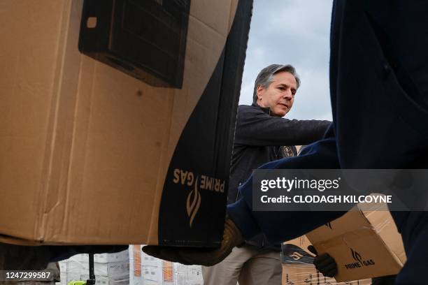 Secretary of State Antony Blinken helps US military personnel carrying aid, at Incirlik Air Base near Adana, on February 19 during his official visit...