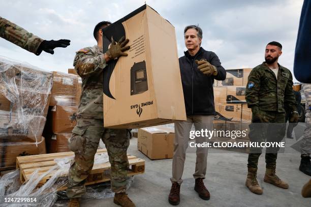 Secretary of State Antony Blinken helps US military personnel loading aid onto a vehicle, at Incirlik Air Base near Adana, on February 19 during his...