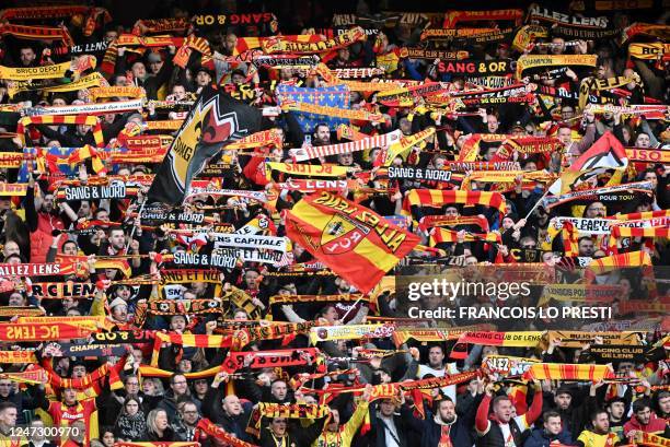 Lens' supporters hold scarfs during the French L1 football match between RC Lens and FC Nantes at Stade Bollaert-Delelis in Lens, northern France, on...