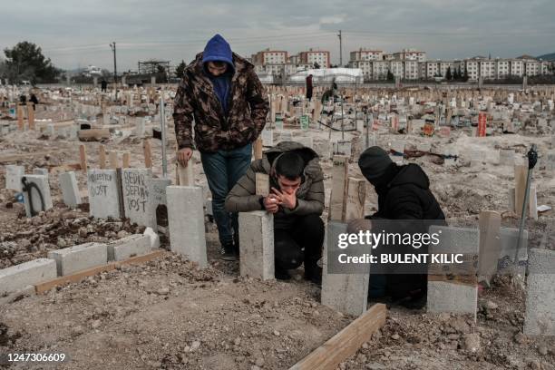Mourners kneel by gravestones in the cemetery of Adiyaman, in Turkey, on February 19 after a 7,8-magnitude earthquake struck parts of Turkey and...