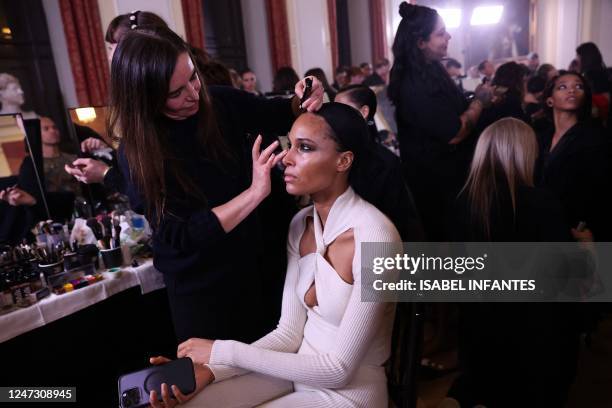 Models have their hair and make-up prepared backstage before presenting British designer Julien Macdonald's Autumn/Winter 2023 collection on the...