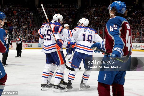 Ryan Nugent-Hopkins, Leon Draisaitl and Zach Hyman of the Edmonton Oilers celebrate a goal against the Colorado Avalanche at Ball Arena on February...